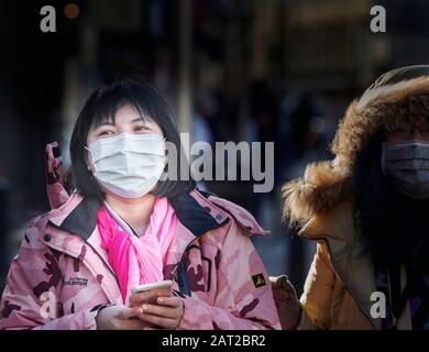 Masque de visage porté par un touriste chinois à l'extérieur de la gare de Cambridge, en Angleterre, le 30 janvier 2020, pour éviter de attraper la grippe coronavirus. Banque D'Images