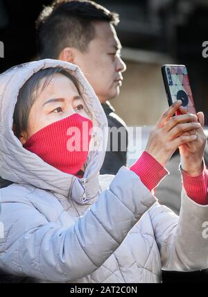 Masque de visage porté par un touriste chinois à l'extérieur de Trinity College, Cambridge, Angleterre, le 30 janvier 2020, pour empêcher de attraper la grippe de coronavirus. Banque D'Images