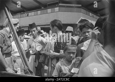 Photo Reportage Palembangs [photo prise d'une jeep dans une rue commerçante. Sur la droite, un shottrooper. Les vendeurs proposent des marchandises dans la rue (par ex. montres ou horloges)] Date : janvier 1947 lieu : Indonésie, Antilles néerlandaises de l'est, Palembangs, Sumatra Banque D'Images
