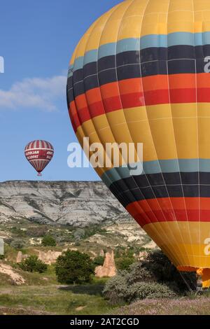 Göreme, TURQUIE - 25 MAI 2009 : un ballon d'air chaud atterrit dans un champ après un vol matinal au-dessus du paysage de Cappadoce de la Turquie. Banque D'Images