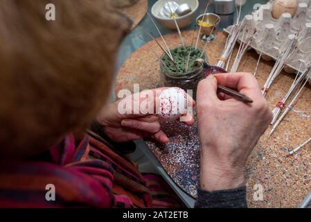 28 janvier 2020, Brandenburg, Lübbenau: Bärbel Lange siège dans son atelier sur les œufs sorbiens. Elle décorera les œufs blancs de poulet toute l'année en utilisant la technique de batik de cire et la technique de bossier. Après environ deux heures, les œufs de poule simples et peu visibles sont transformés en petites œuvres d'art. les Sorbes de la Lauritz sont célèbres pour la décoration artistique des œufs de Pâques. Photo : Stephan Schulz/dpa-Zentralbild/ZB Banque D'Images