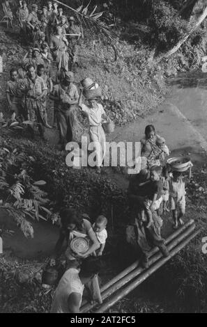 Garoet. Patrouilles de purification. Guirlande Chinoise. La patrouille de purification a trouvé un certain nombre de familles chinoises se cachant dans une maison de camp de la T.N.I. Avec les quelques articles ménagers laissés, ils sont transportés vers des zones plus sûres par leurs libérateurs. Date : Octobre 1947 Lieu : Indonésie, Antilles Néerlandaises De L'Est Banque D'Images