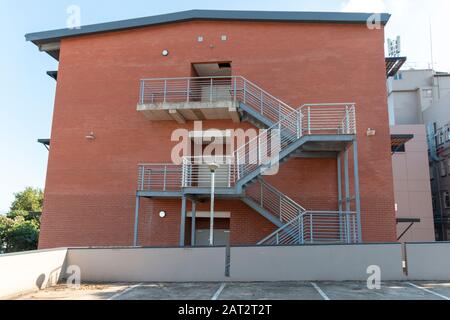 Vue rapprochée d'un escalier métallique qui monte sur le côté d'un bâtiment nouvellement construit Banque D'Images