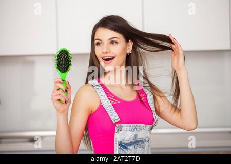 Girl est titulaire d'une brosse sans cheveux et souriant Banque D'Images