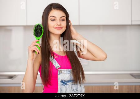 Girl est titulaire d'une brosse sans cheveux et souriant Banque D'Images