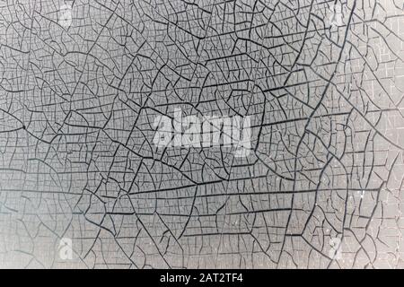 Vue rapprochée de la teinture sur une fenêtre qui s'est fissurée et a commencé à se décoller après le temps Banque D'Images