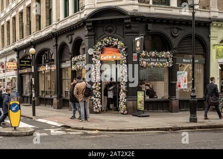 Londres / Royaume-Uni - 28 novembre 2019 : les gens qui marchent devant le café Coco Fresh Tea & Juice sur Great Russell Street juste en face du British Museum à Holborn, L Banque D'Images