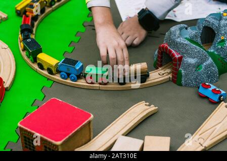 La main des enfants conduit un train en bois jouet. Un jeu passionnant pour les enfants à la maternelle ou à l'école Banque D'Images