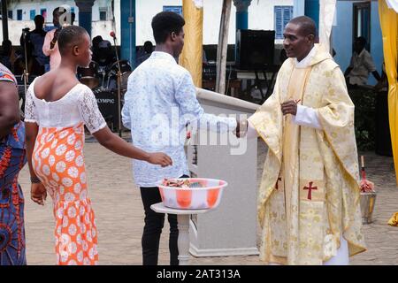 Contribution d'argent pendant la masse du dimanche catholique romain. Rév. Fr. Anthony Assebiah, Paroisse De La Messe Sainte Marie Du Dimanche À Kengen / Ghana, Afrique Banque D'Images