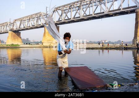 Uttar Pradesh, Inde - 03 mars 2018: Un homme non identifié faisant une lessive à Dhobi Ghat est une laverie en plein air bien connue dans la rivière Yamuna, Agra. Banque D'Images