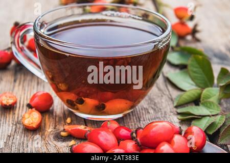 Tasse de thé au rosehip avec des baies fraîches sur une table en bois. Phytothérapie. Banque D'Images