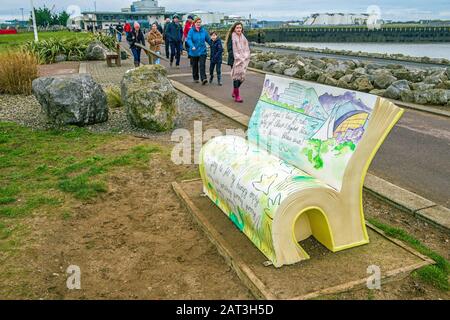 Sculpture d'un livre Roald Dahl, installé sur le barrage de la baie de Cardiff avec un groupe de personnes approchant rapidement. Roald Dahl est né à Cardiff Banque D'Images