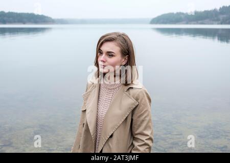 Belle jeune femme debout près d'un lac Banque D'Images