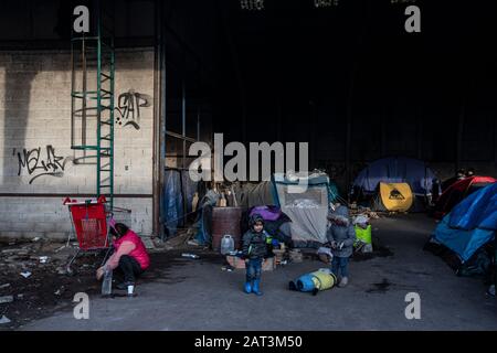 Les immigrants kurdes irakiens qui prennent refuge dans des tentes parmi les décombres d'un entrepôt abandonnée à la périphérie de Dunkerque alors qu'ils essaient de rejoindre la Grande-Bretagne. Banque D'Images