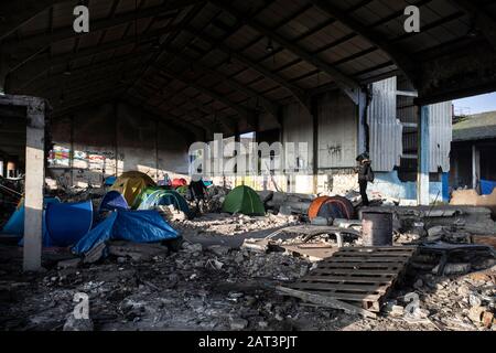 Les immigrants kurdes irakiens qui prennent refuge dans des tentes parmi les décombres d'un entrepôt abandonnée à la périphérie de Dunkerque alors qu'ils essaient de rejoindre la Grande-Bretagne. Banque D'Images