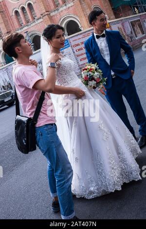 Mariée & marié dans la rue ayant des photos d'album de mariage prises, Ho Chi Minh Ville, Vietnam Banque D'Images