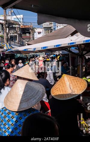 Les femmes portent des chapeaux coniques sur le marché de la rue, Ho Chi Minh Ville, Vietnam Banque D'Images