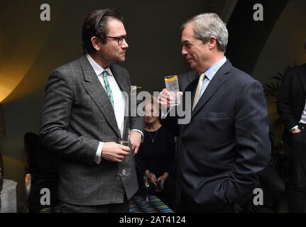 Nigel Farage parle à l'artiste Dan Llywelyn Hall (à gauche) lors du dévoilement d'un portrait de lui-même intitulé M. Brexit, au restaurant l'Escargot à Londres. Banque D'Images