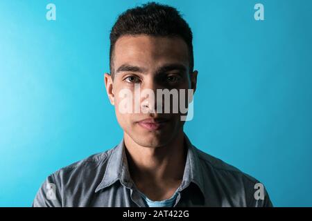 Gros plan portrait beau mulatto homme dans une sombre. Prise de vue en studio Banque D'Images