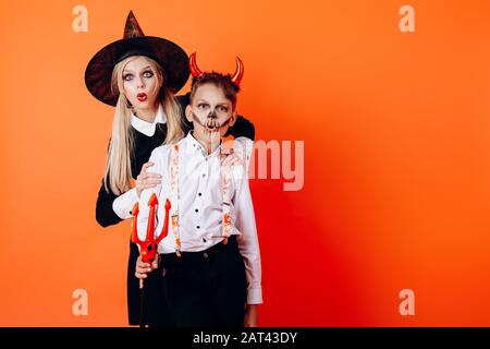 Femme et garçon dans le diable mascarade maquillage montrant l'émotion émerveilissante. Concept d'Halloween Banque D'Images