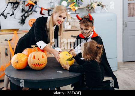 Mère et enfants s'appuyant sur la citrouille, jouer et avoir le temps drôle à la maison. -concept d'Halloween Banque D'Images