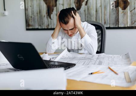 Stressed businessman with head in hands dans son bureau Banque D'Images