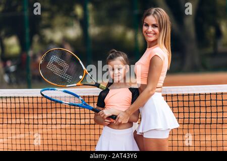 Bonne mère et fille ont un excellent séjour sur le cordon de tennis Banque D'Images