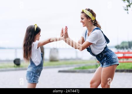 Maman et fille jouent avec plaisir dans la rue et se regardent les uns les autres.- image Banque D'Images