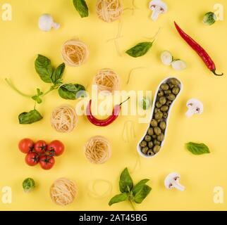 Vue de dessus, délicieux ingrédients disposés sur fond jaune. Concept de cuisine italienne Banque D'Images