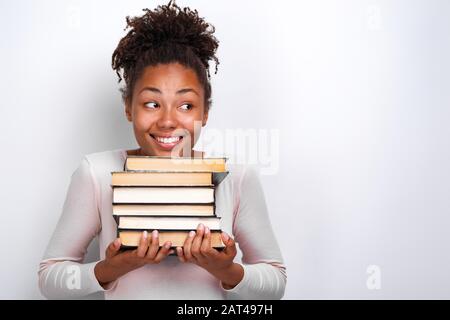 Portrait de heureuse jeune fille nerd tenant des livres sur fond blanc. Retour à l'école Banque D'Images