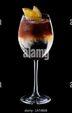 Espresso et cocktail tonique dans un verre à vin isolé sur fond noir Banque D'Images