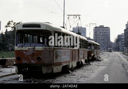 17 août 1993 Durant le siège de Sarajevo : la vue ouest le long d'Obala Kulina bana dans le centre-ville : des tramways épaves sont abandonnés le long de la rue déserte. Banque D'Images