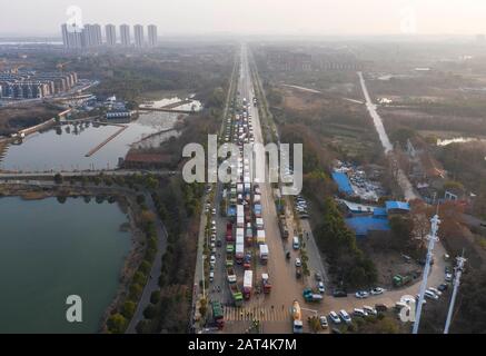 Wuhan. 30 janvier 2020. La photo aérienne prise le 30 janvier 2020 montre des camions qui s'approchent du chantier de construction de l'hôpital Huoshenshan (Fire God Mountain) à Wuhan, dans la province de Hubei en Chine centrale. Plus de 4 000 travailleurs et environ 1 000 véhicules et de grandes machines se sont mis à l'abri de la toilette sur le site de l'hôpital jour et nuit. Le principal pipeline du système de drainage dans le site de l'hôpital est en grande partie terminé et l'hôpital devrait être mis en service le 3 février. Crédit: Cai Yang/Xinhua/Alay Live News Banque D'Images