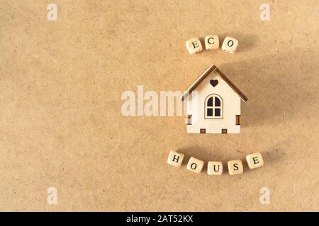 Maison écologique - petite maison modèle jouet avec inscription mot ECO MAISON sur le fond de cartboard kraft. Zéro déchet, recyclage, vie durable, recyclage, concept de maison verte Banque D'Images