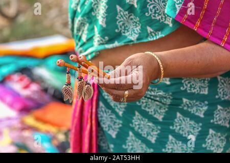 Femme à la main vendant des cheveux faits à la main des clips à un tarif artisanal à Shantiniketan, Bengale occidental. Photo prise avec mise au point sélective Banque D'Images