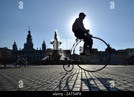 Un cavalier sur un vélo historique sur la place de Premysl Otakar II à Ceske Budejovice, le 15 juin 2017, avec la silhouette de la construction historique de l'hôtel de ville Banque D'Images