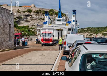 Voitures en attente d'entrer dans MS Ichnusa, ferry venant de Santa Teresa Gallura, Sardaigne, amarré à la Gare Maritime au port de Bonifacio, Corse, France Banque D'Images
