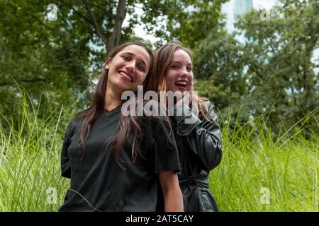 Portrait de deux jeunes femmes heureux de différents milieux raciaux. Un penchant contre l'autre. Prise de vue moyenne. Banque D'Images