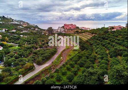 Almuñécar bord de mer colline ville photo aérienne, drone point de vue. Collines pittoresques, vallées, paysage agricole. Moody ciel nuageux au-dessus de la mer Espagne Banque D'Images