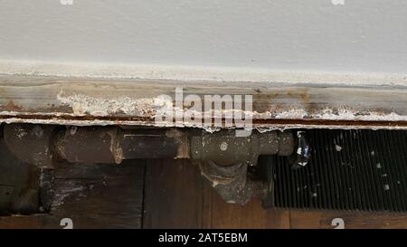 Un vieux radiateur d'eau chaude avec des déflecteurs et des vannes utilisés pour chauffer des appartements à New York Banque D'Images