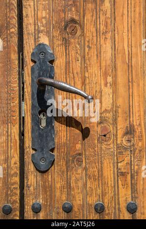 Porte massive en bois brun ancien, porte fermée, entrée double avec poignées en fer à la main et défonces Banque D'Images