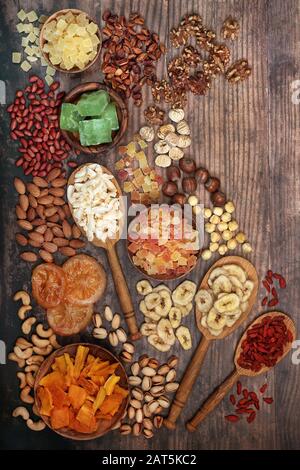 Assortiment de fruits secs et de noix sur fond rustique en bois. Nourriture de santé élevée en antioxydants, protéines, oméga 3. Minéraux, vitamines et anthocyanines. Banque D'Images