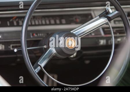 Détail détaillé de l'intérieur avant d'un Chrysler 300 rouge vintage des années 60 montrant le tableau de bord et le volant Banque D'Images