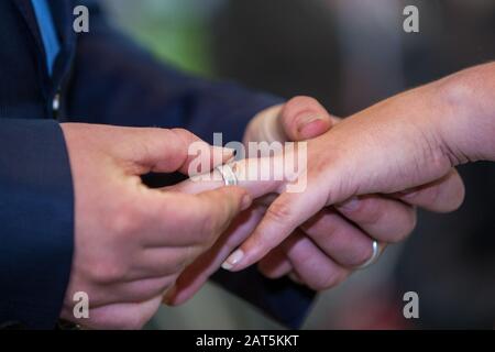 Un méconnaissable mariés l'échange des anneaux de mariage à l'église pendant la cérémonie du mariage chrétien Banque D'Images