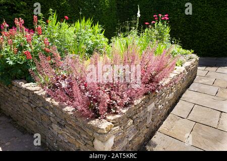 Semoir levé à parois de pierre sèche dans un jardin en contrebas à l'abri dans le Wiltshire Royaume-Uni Banque D'Images