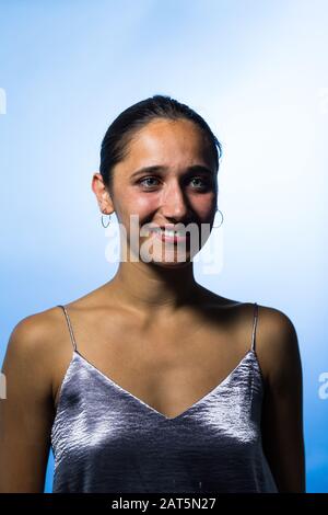 Portrait de la jeune femme souriant sur fond bleu ciel. Prise de vue moyenne. Banque D'Images