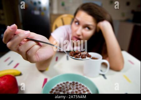 jeune fille montre dégoût au petit déjeuner. La femme montre la satiété et ne veut pas manger Banque D'Images