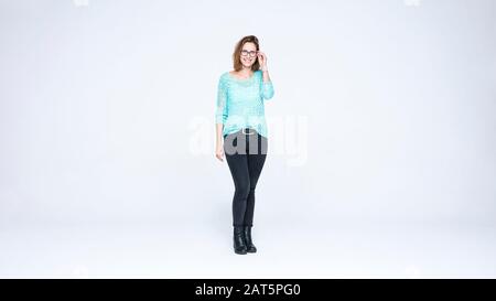 Femme souriante dans des lunettes debout sur fond blanc. femme d'affaires avec les cheveux bruns courts regardant la caméra. Banque D'Images