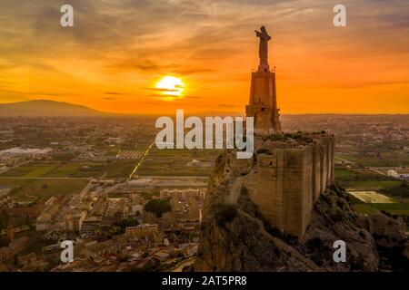 Le château médiéval de Monteagudo ruine douze tours rectangulaires entourant le sommet de la colline et le coeur sacré de la statue de Jésus-Christ au sommet près de Murcie Espagne Banque D'Images