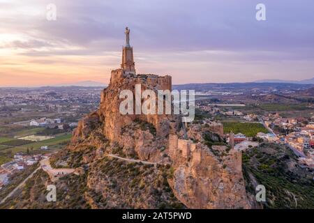 Le château médiéval de Monteagudo ruine douze tours rectangulaires entourant le sommet de la colline et le coeur sacré de la statue de Jésus-Christ au sommet près de Murcie Espagne Banque D'Images